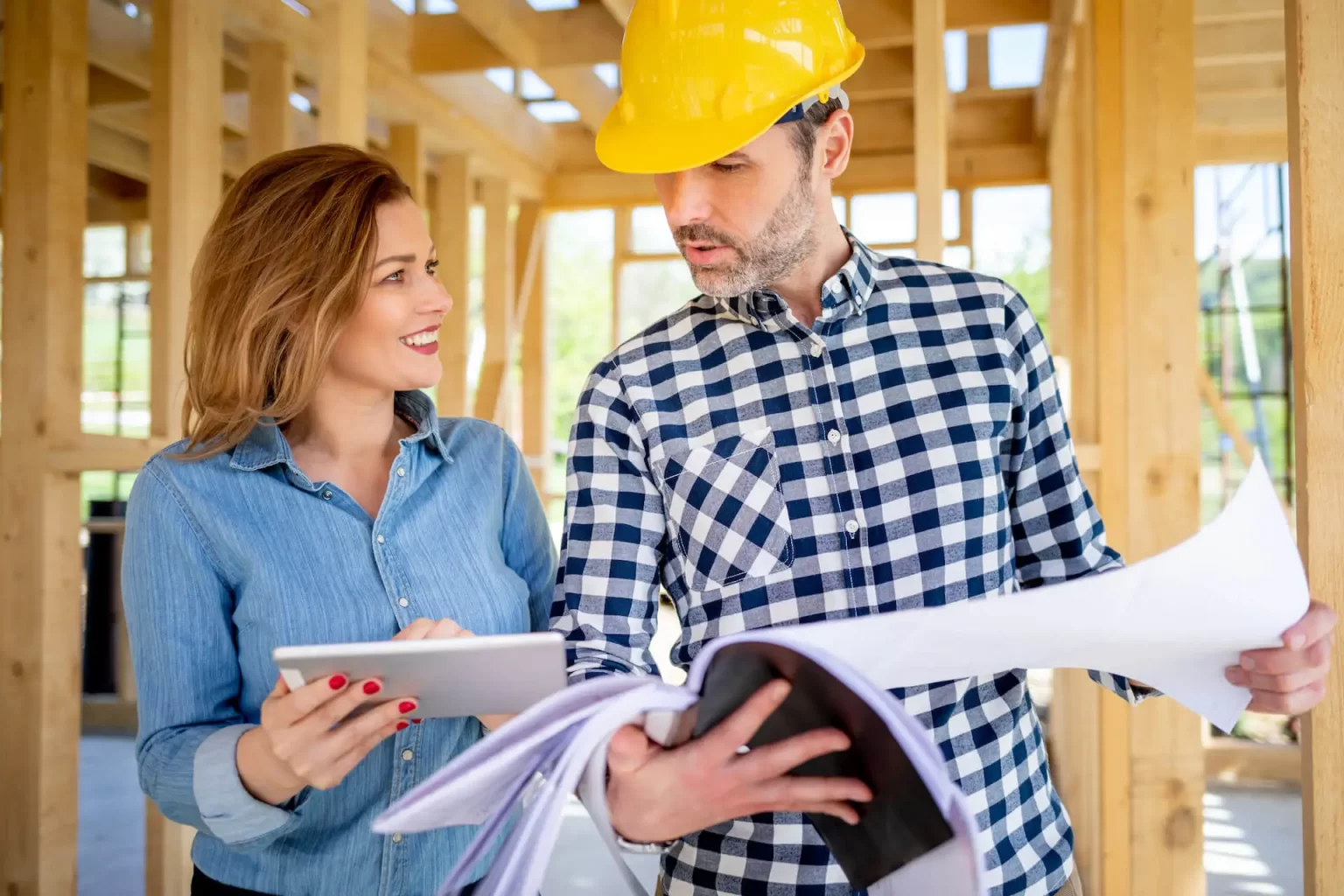 female-homeowner-consults-blueprints-with-architec-2021-08-28-15-56-16-utc